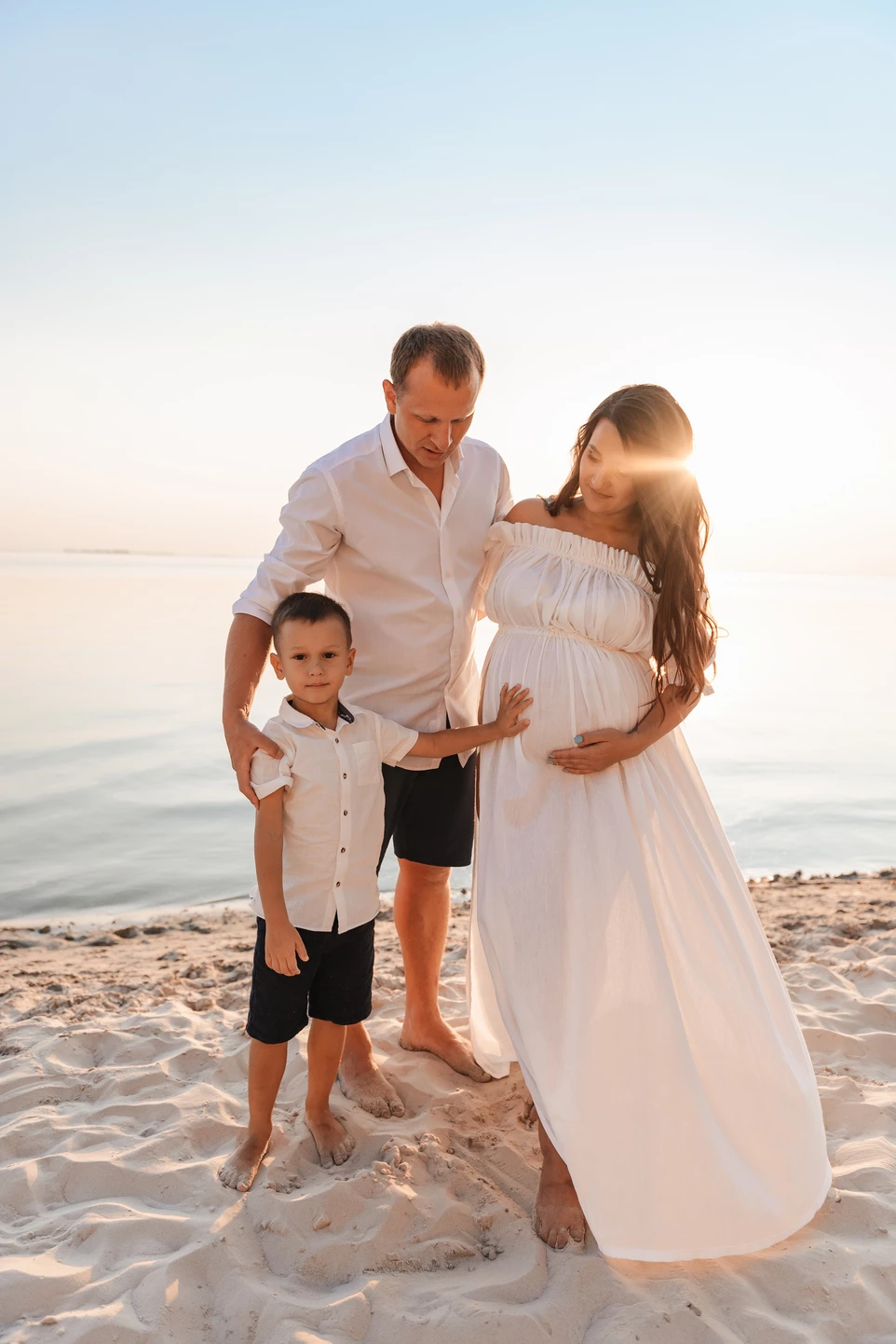 Фотосесія сім'ї з вагітною мамою та маленьким сином насолоджується днем на пляжі