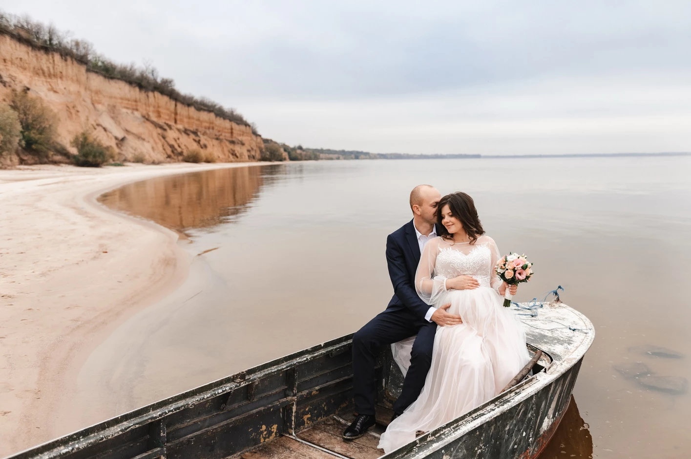 Чарівний момент з фотосесії вагітності на березі озера в Кременчуці, де пара позує на човні.